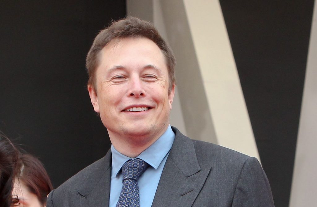 --FILE--Tesla CEO Elon Musk, right, poses with a buyer of Tesla Model S electric cars during a delivery ceremony at the sales center of Tesla in Jinqiao, Shanghai, China, 23 April 2014. US electric car manufacturer Tesla yesterday broke ground on its Shanghai factory, becoming the first company to benefit from a new policy that allows foreign carmakers to set up wholly owned subsidiaries in China. The new plant, Tesla's first outside the United States, is located in Lingang, southeast Shanghai. The factory, which is Shanghai's largest foreign invested manufacturing project, will initially have an annual capacity of 250,000 electric vehicles in the first phase, eventually rising to 500,000 cars a year when fully operational.