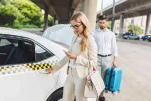 Young woman uses cell phone while waiting for a taxi
