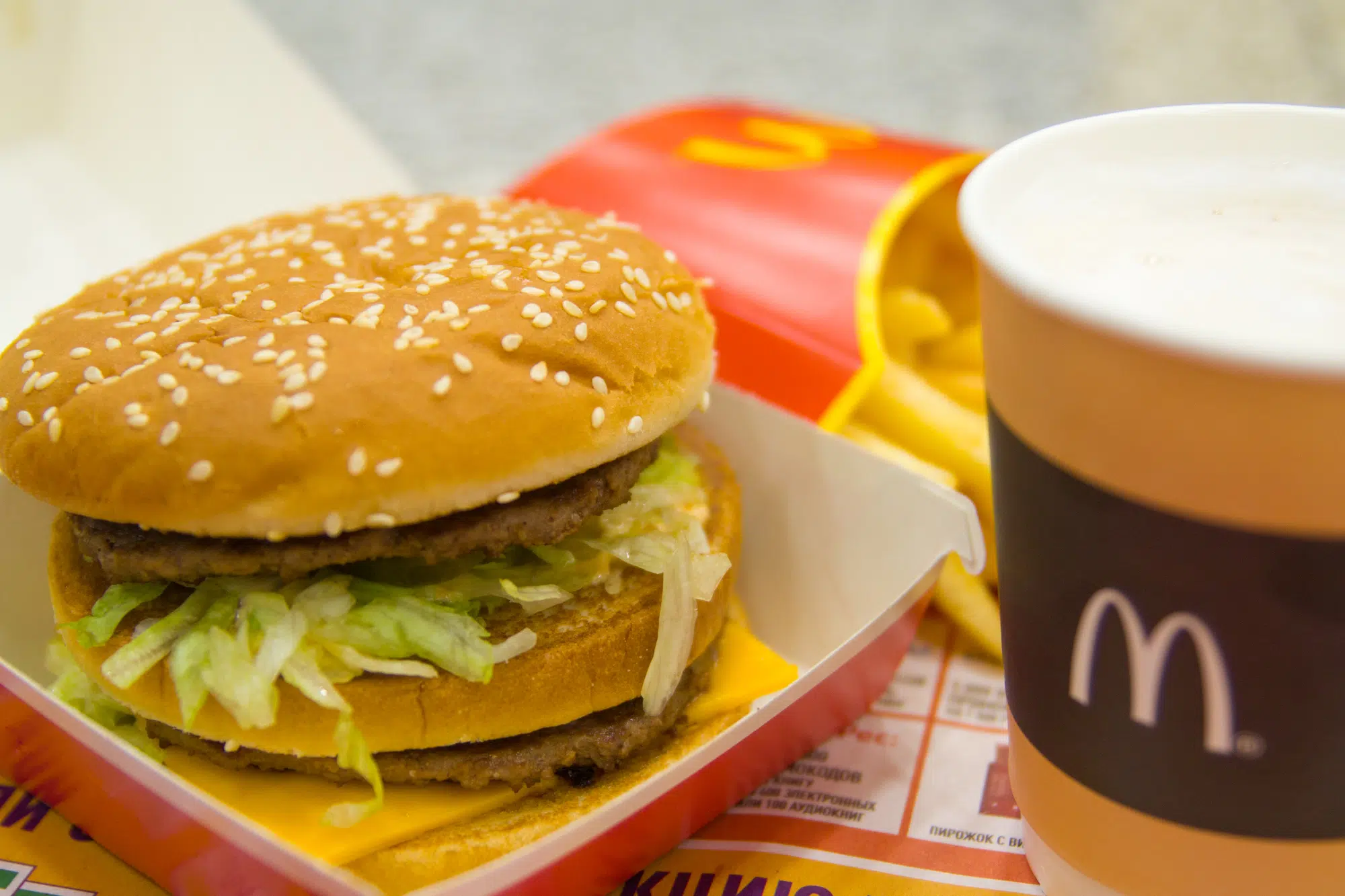 Hamburger menu in McDonald's restaurant. Fries, coffee capuccino, Big Mac. Fastfood and junk food concept