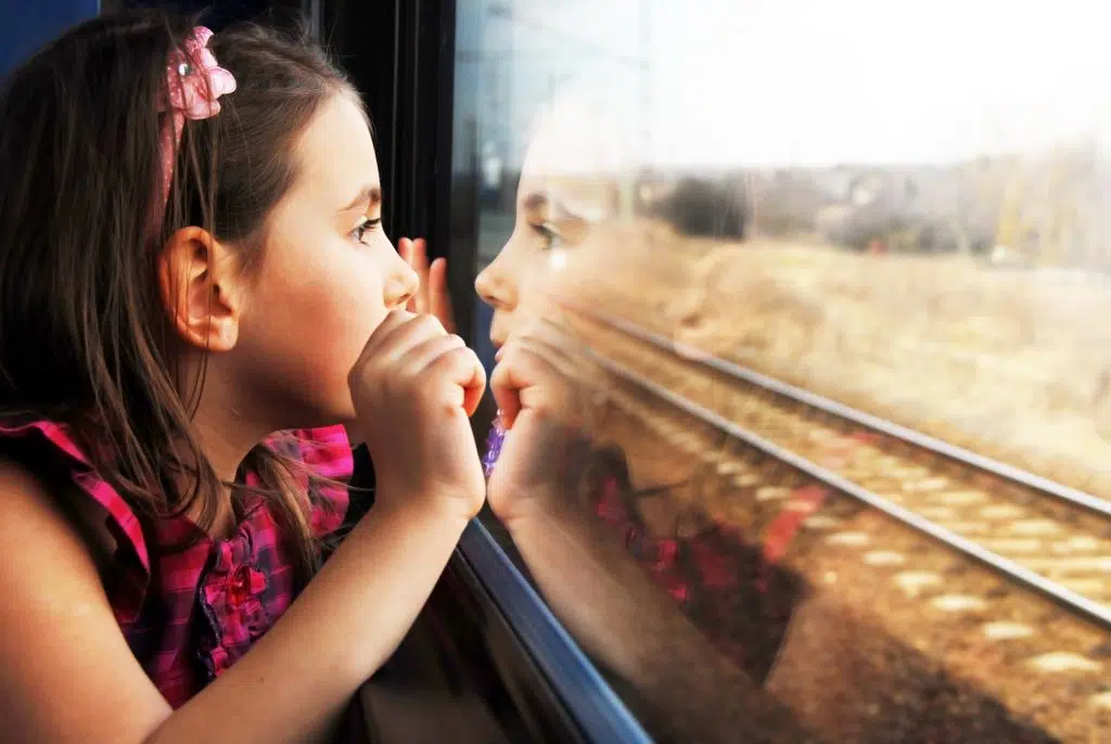 The girl looks through the train window