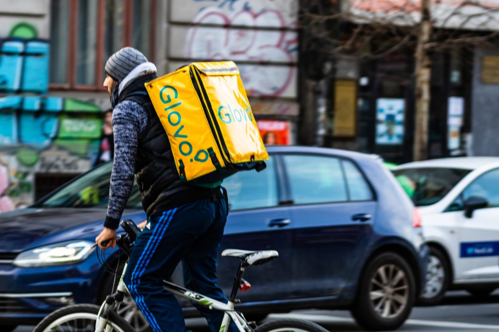 A Glovo food delivery courier on a bike. Restaurants are closed and only deliveries are allowed during the state of emergency due to coronavirus COVID-19 outbreak in Bucharest, Romania, 2020