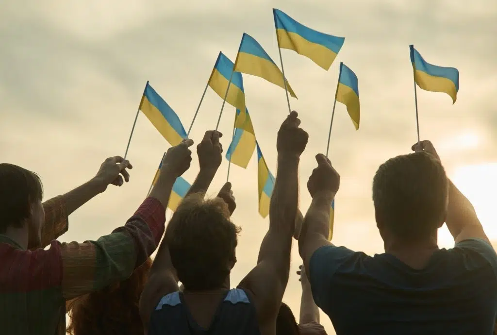 People hold ukrainian flags.