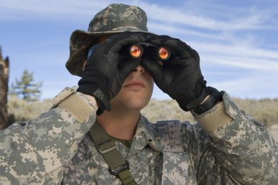Soldier looking through binoculars, close-up