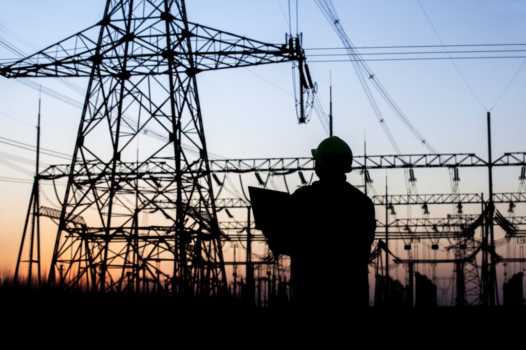 Electricity workers and pylon silhouette