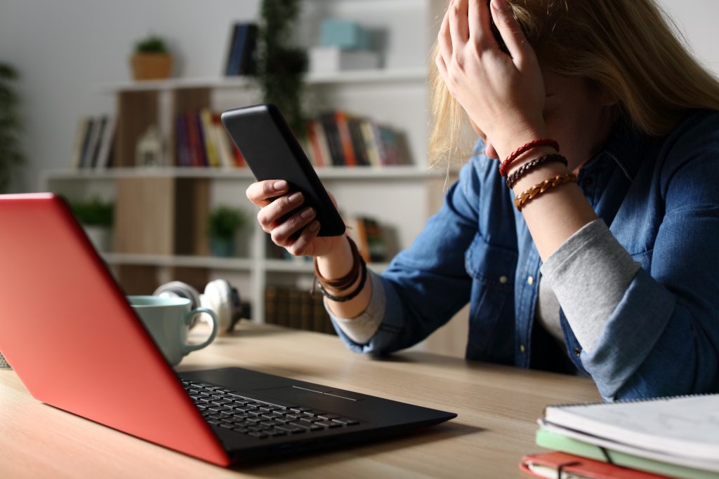 Sad student reading bad news on phone at night