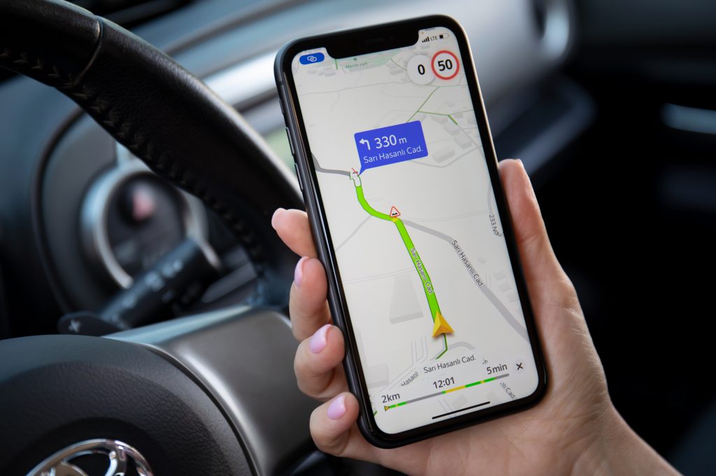 Woman hand holding Apple iPhone 11 with Yandex Navigation Maps