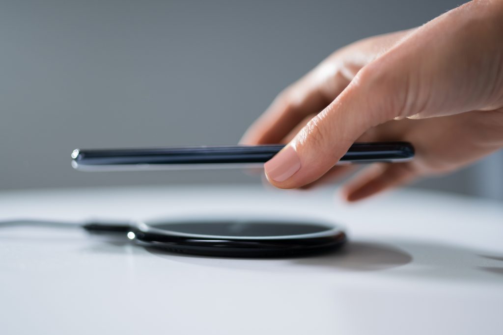 Woman Charging Smartphone Using Wireless Charging Pad