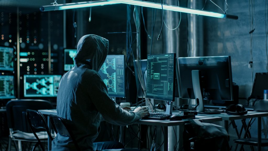 Hooded Hacker Using His Comuter with Different Information to Br