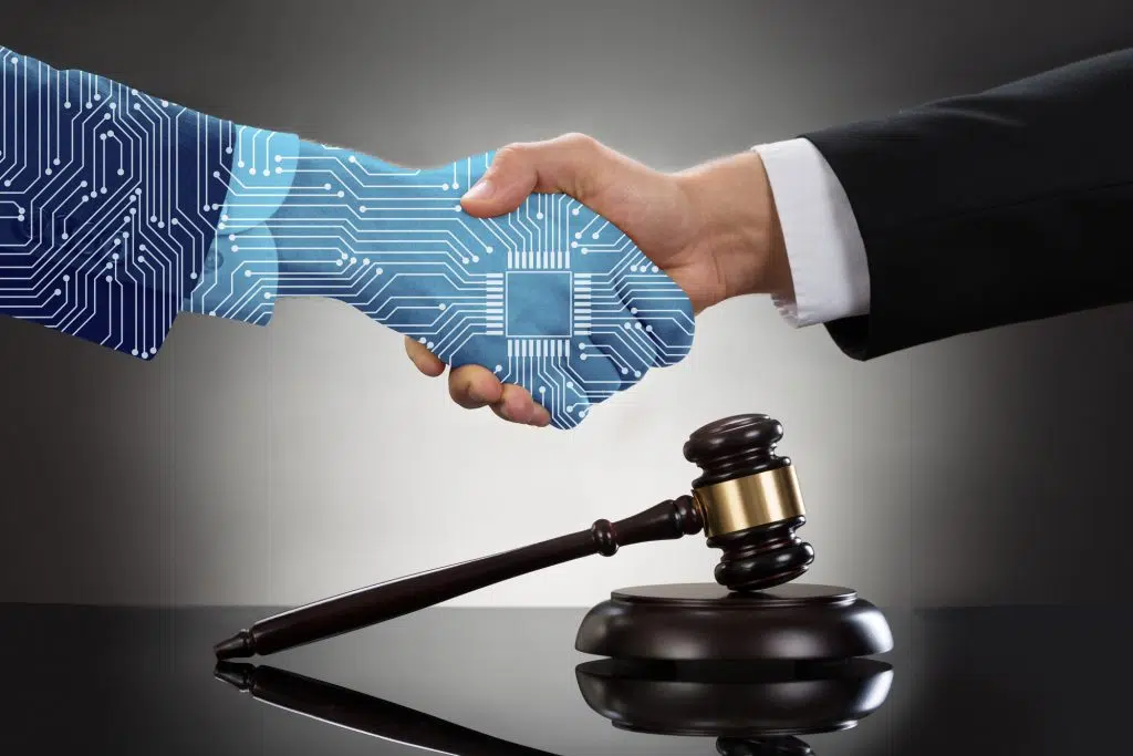 Digital Generated Human Hand And Businessman Shaking Hands Over Gavel Against Grey Background