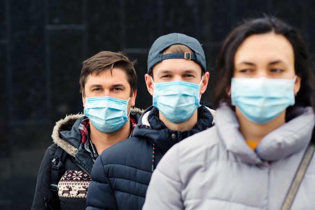 Crowd of people wearing medical masks. Coronavirus epidemic concept. Group of young volunteers outdoors.