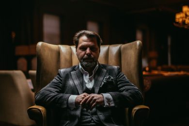 Bearded businessman thinks about important while sitting in leather armchair.