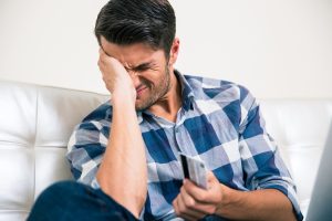 Sad man holding bank card