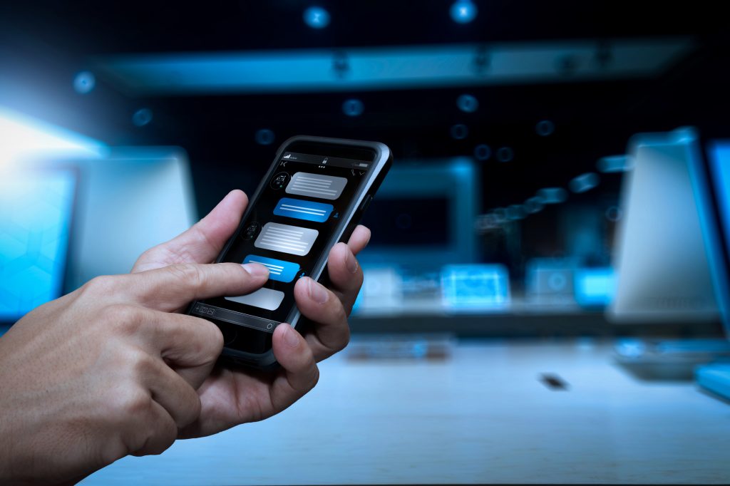 Chatbot conversation with smartphone screen app interface and artificial intelligence technology processing virtual assistant with customer support information, business hand holding mobile phone.