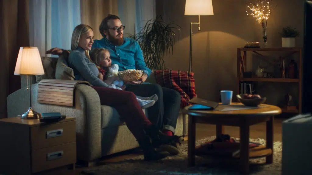 Long Shot of a Father, Mother and Little Girl Watching TV. They