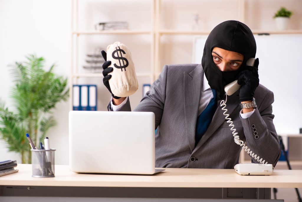 Male gangster stealing information from the office