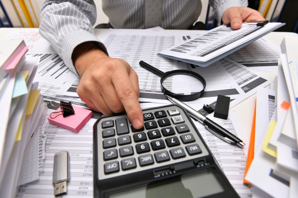business concept - businessman working with reports in office, table and workspace close view, analyzing financial data, writes and counts