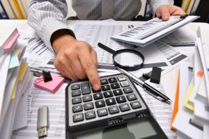 business concept - businessman working with reports in office, table and workspace close view, analyzing financial data, writes and counts
