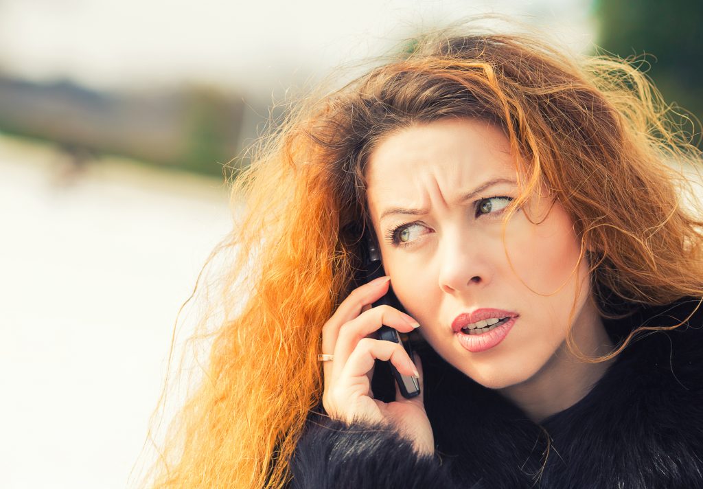 Closeup portrait upset sad, skeptical, unhappy, serious woman talking on phone, standing outdoor. Negative human emotions, facial expressions, feelings, life reaction. Bad news perception