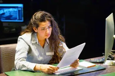 A woman-reception hotel worker reading negative news in letter. Shocked beauty girl business manager received layoff message letter from company feeling surprised. An agitated girl without joy.