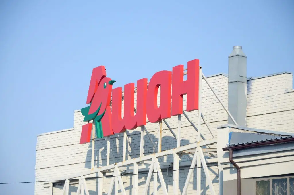KHARKOV, UKRAINE - OCTOBER 20, 2019: Auchan supermarket logo on the building roof. Auchan is French international retail group