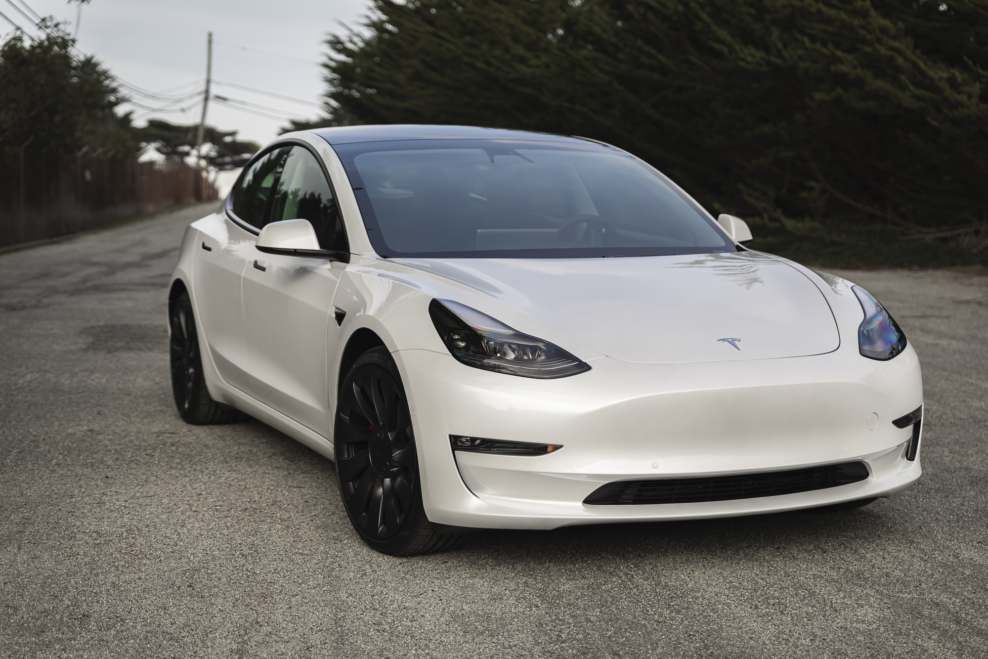 Moss Beach USA - January 1, 2021: Pearl white electric Tesla Model 3 dual motor performance AWD car with 20 inch Uberturbine wheels near San Francisco