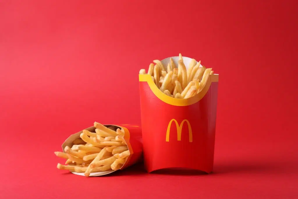 MYKOLAIV, UKRAINE - AUGUST 12, 2021: Two big portions of McDonald's French fries on red background