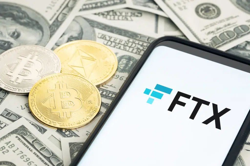 Galicia, Spain; january 28, 2022: FTX logo on Smartphone screen and dollar banknotes and bitcoin and ethereum coins