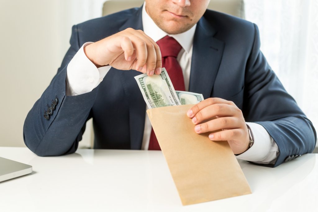 Conceptual photo of bribed politician taking envelope with money