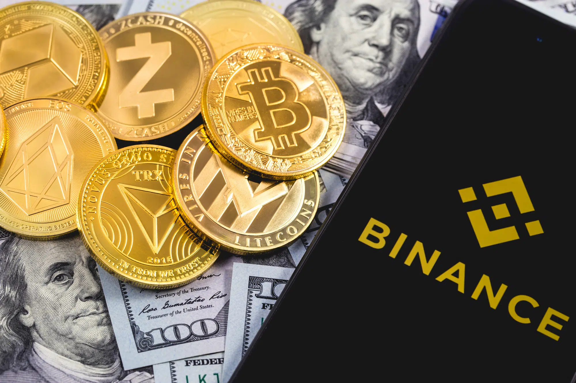 Apple iPhone and Binance logo, and dollars, cryptocurrency. Binance is a cryptocurrency exchange. Ekaterinburg, Russia - September 19, 2018