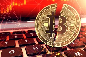 Bitcoin split in two pieces on keyboard. Frauds and ransoms committed with cryptocurrencies concept. 3D rendering