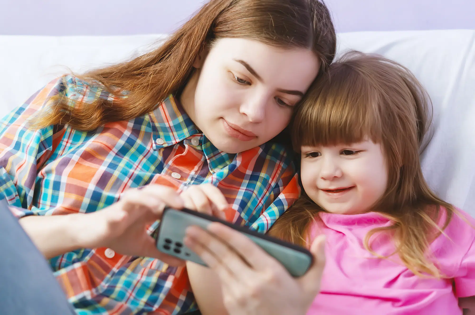 Two girls are playing on a smartphone