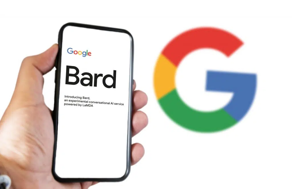 San Francisco US, Feb 2023: A hand holding a phone with the Google Bard website on the screen. White background with blurred Big G logo. Bard is Google artificial intelligence chatbot