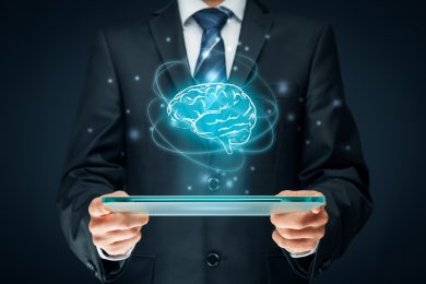 Artificial intelligence (AI), machine deep learning, data mining, expert system software, and another modern computer technologies concepts. Brain representing artificial intelligence and businessman holding futuristic tablet.