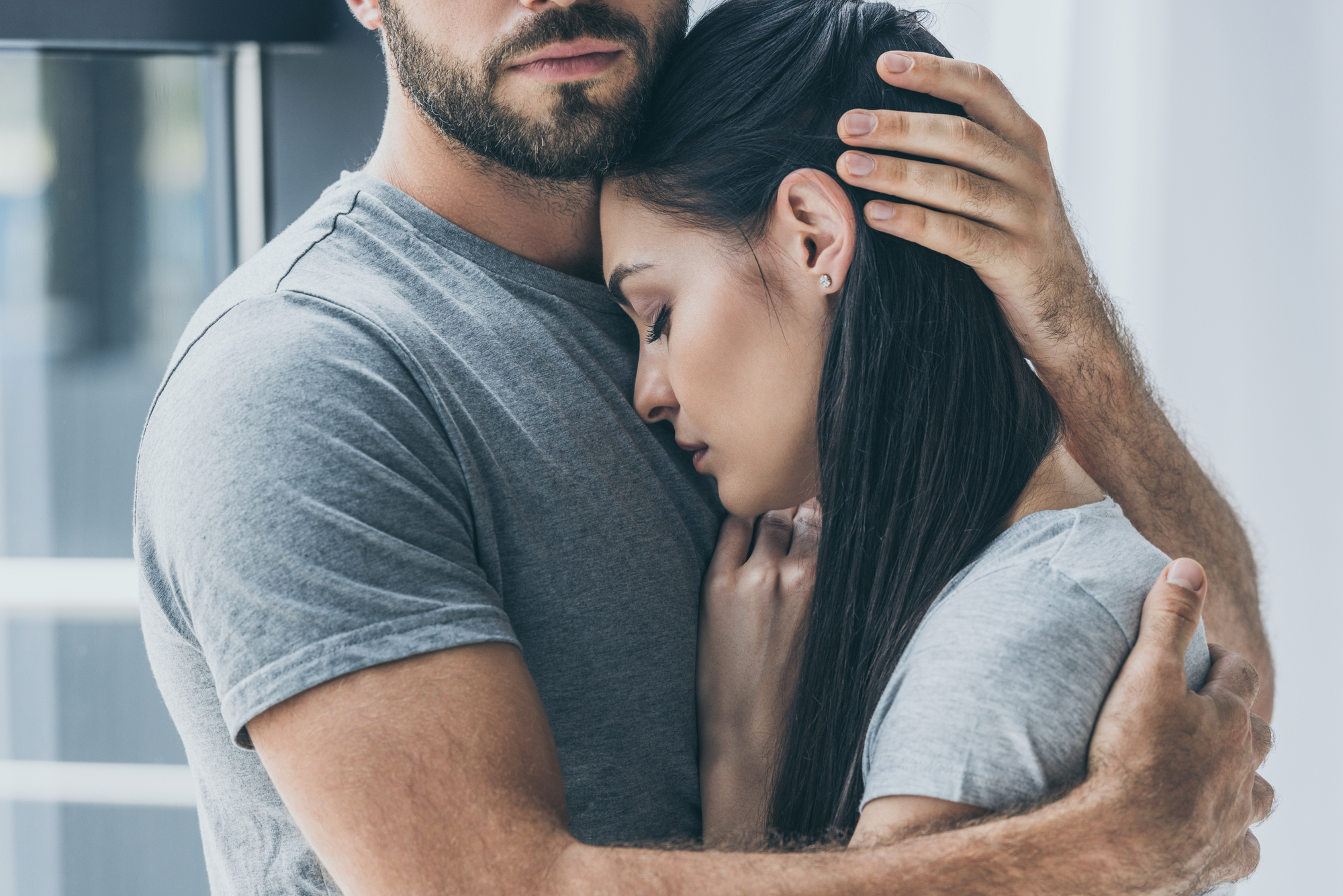 Upset woman in man's arms