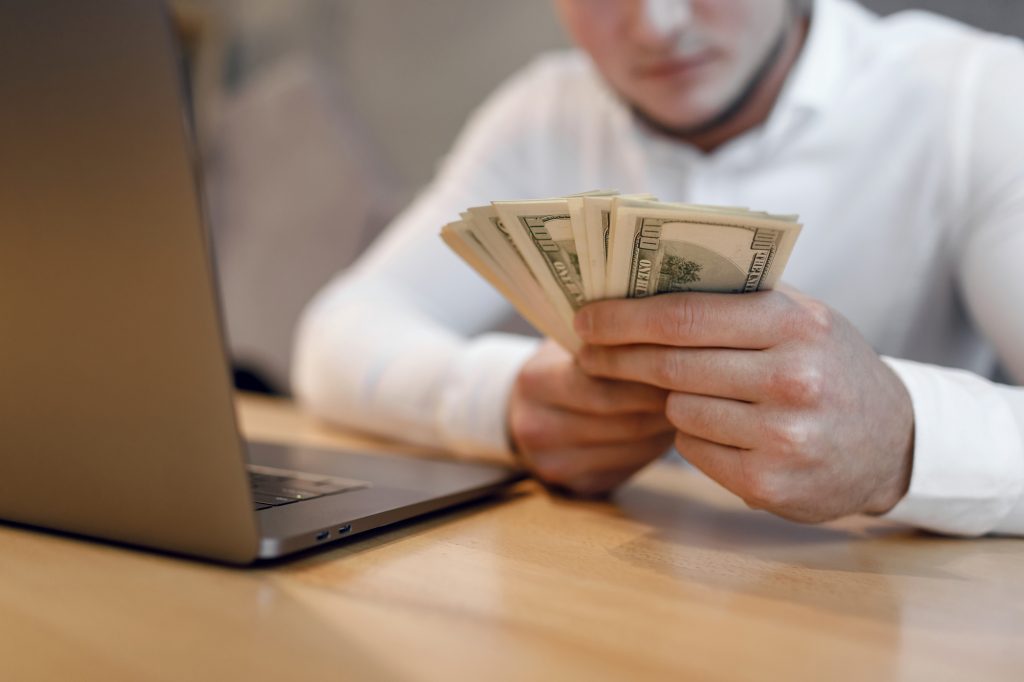 man with laptop and money.