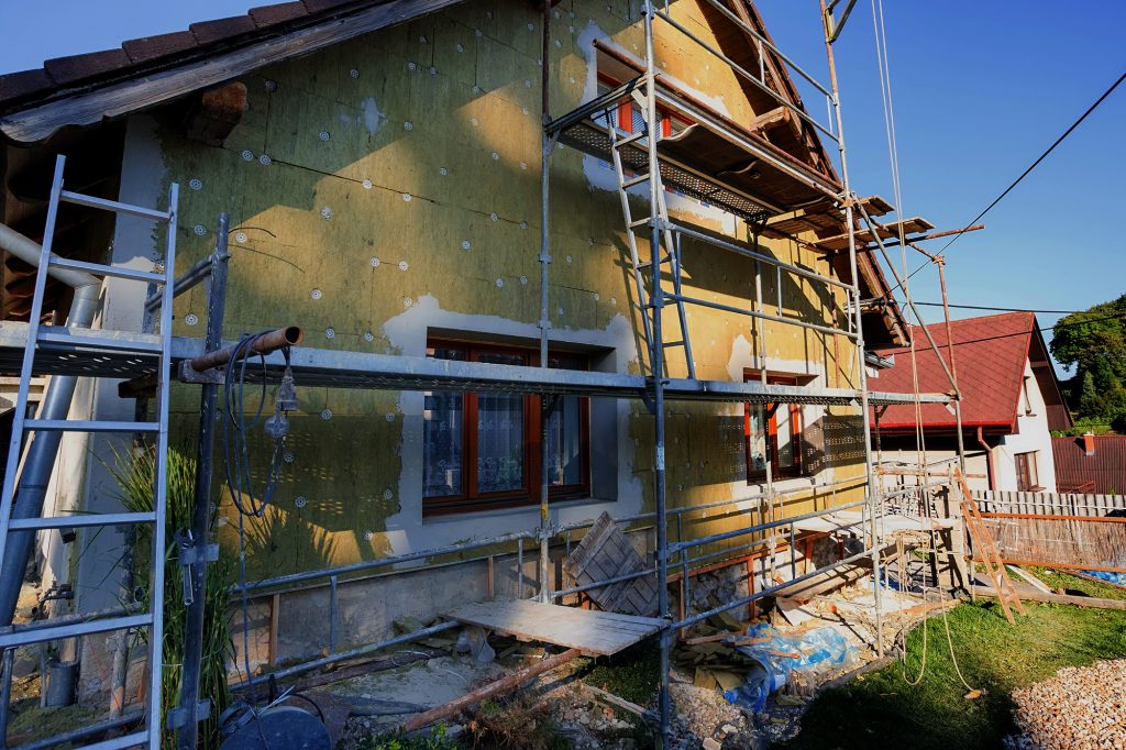 repaired rural house, fixed facade, insulation and painted to green  color witg swimming pool