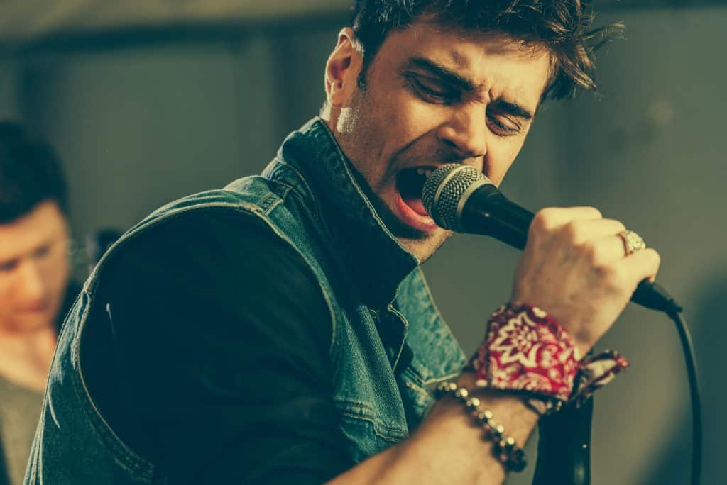 A man sings in a recording studio