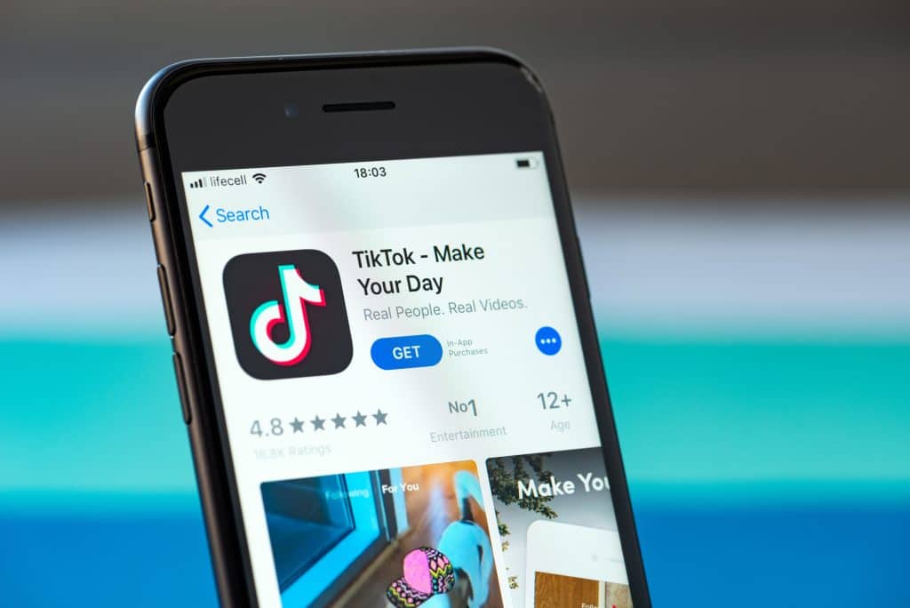 Kyiv, Ukraine - September 17, 2019: Studio shot of Apple iPhone 8 smartphone with TikTok mobile application on the screen, from the download page on App Store platform.