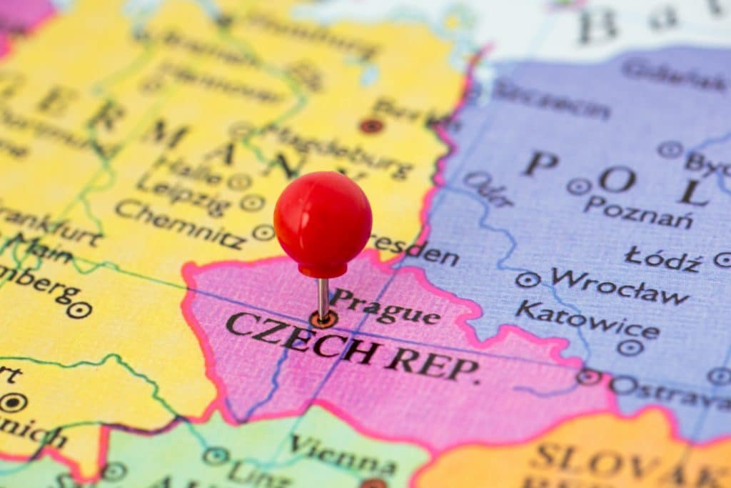 Round red thumb tack pinched through city of Prague on Czech Republic map. Part of collection covering all major capitals of Europe.