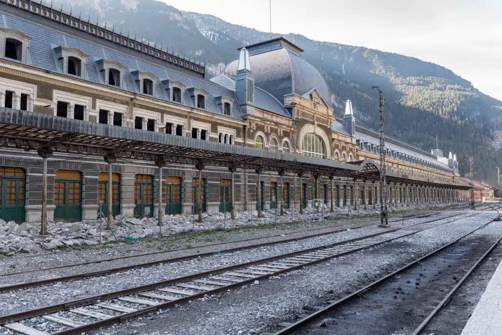 Canfranc, Spain - May 1, 2019 : Railys and main biulding in the Abandoned railway station of Canfranc Huesca Spain