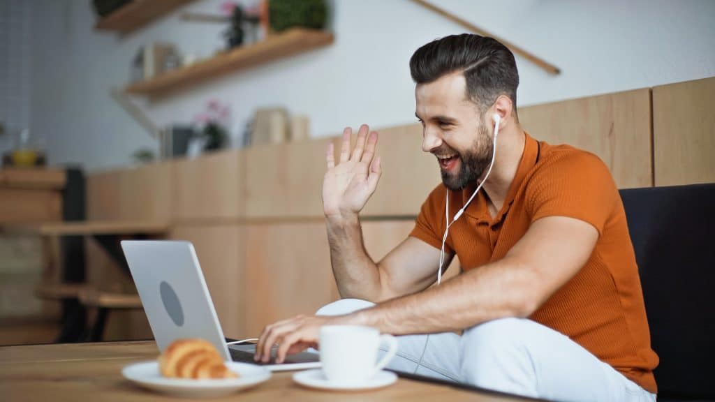 happy man communicates with another person on video