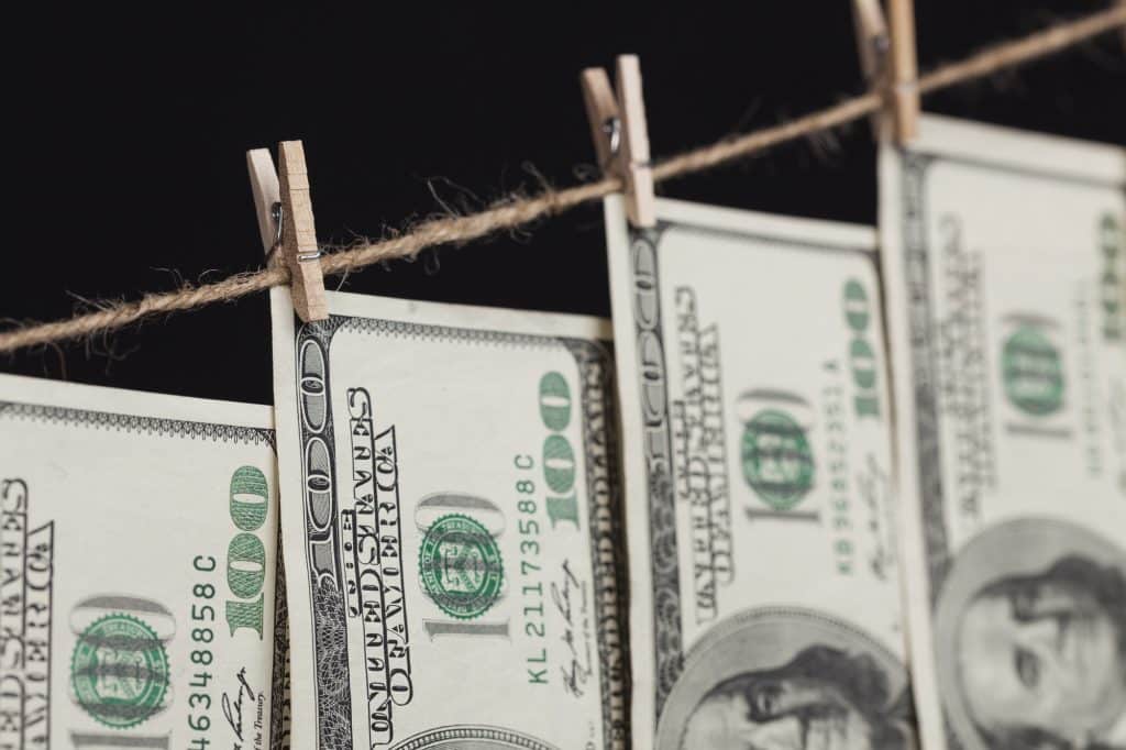 Hundred Dollar Bills Hanging From a Clothesline on a Dark Background.