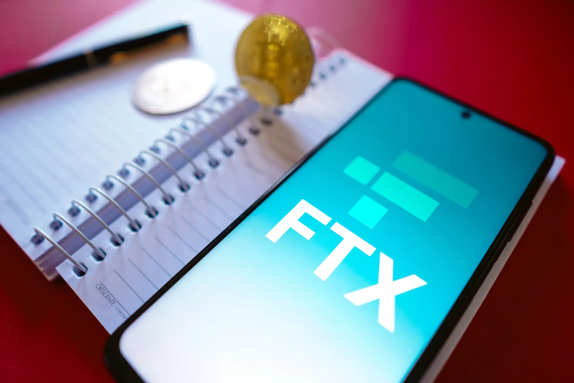 July 19, 2022, Brazil. In this photo illustration the FTX Crypto Derivatives Exchange logo seen displayed on a smartphone screen, on the side of Bitcoin cryptocurrencies