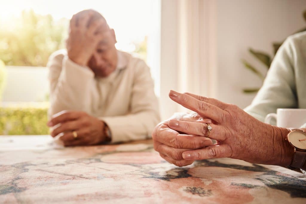 Divorce, closeup and hands with couple, issue and disagreement with anxiety, mental health and marriage. Zoom, man and woman remove ring, frustrated and stress together with problems and issues.