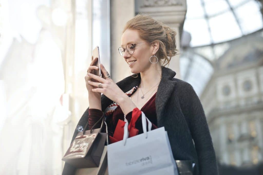 Pretty woman with iPhone by Andrea Piacquadio via Pexels