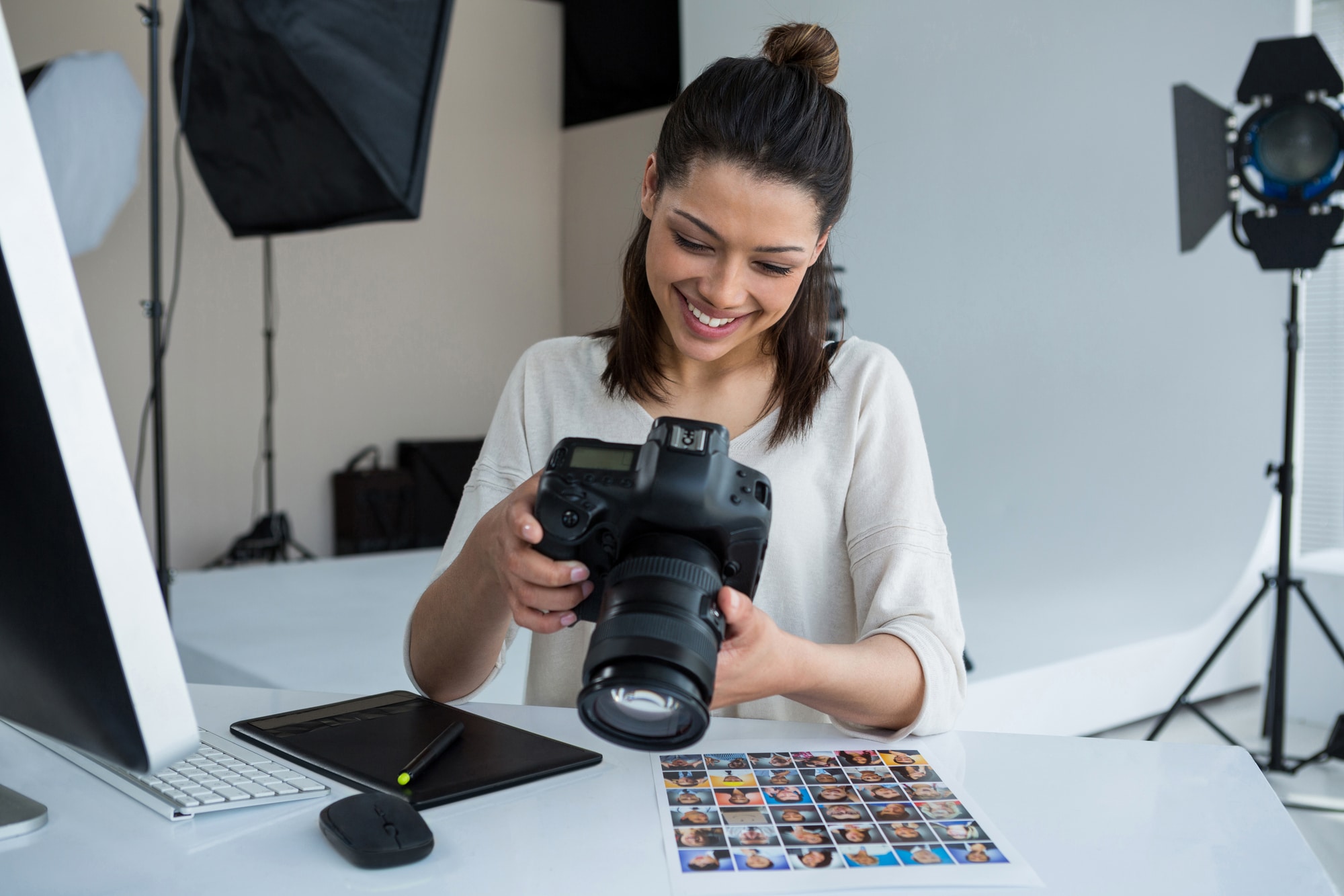 Female photographer reviewing captured photos in her digital camera at studio