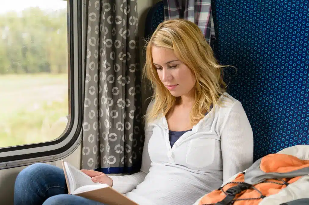 Woman reading while traveling with the train commuter journey sitting