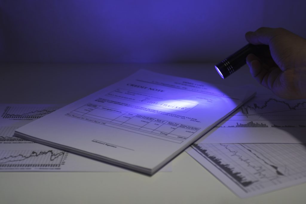 Secret documents reading. Ultra violet light abstract photo. Documents on table under ultra violet light.