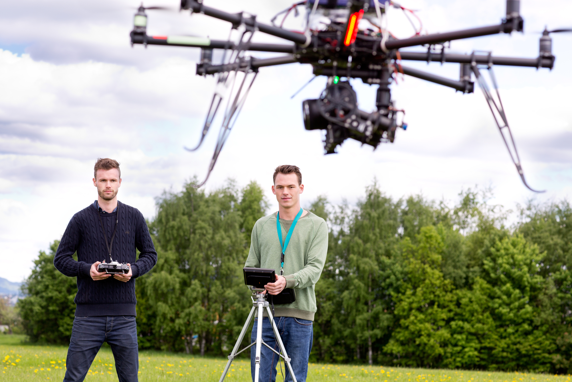 Professional team of a photographer and pilot operating a UAV Photography Drone