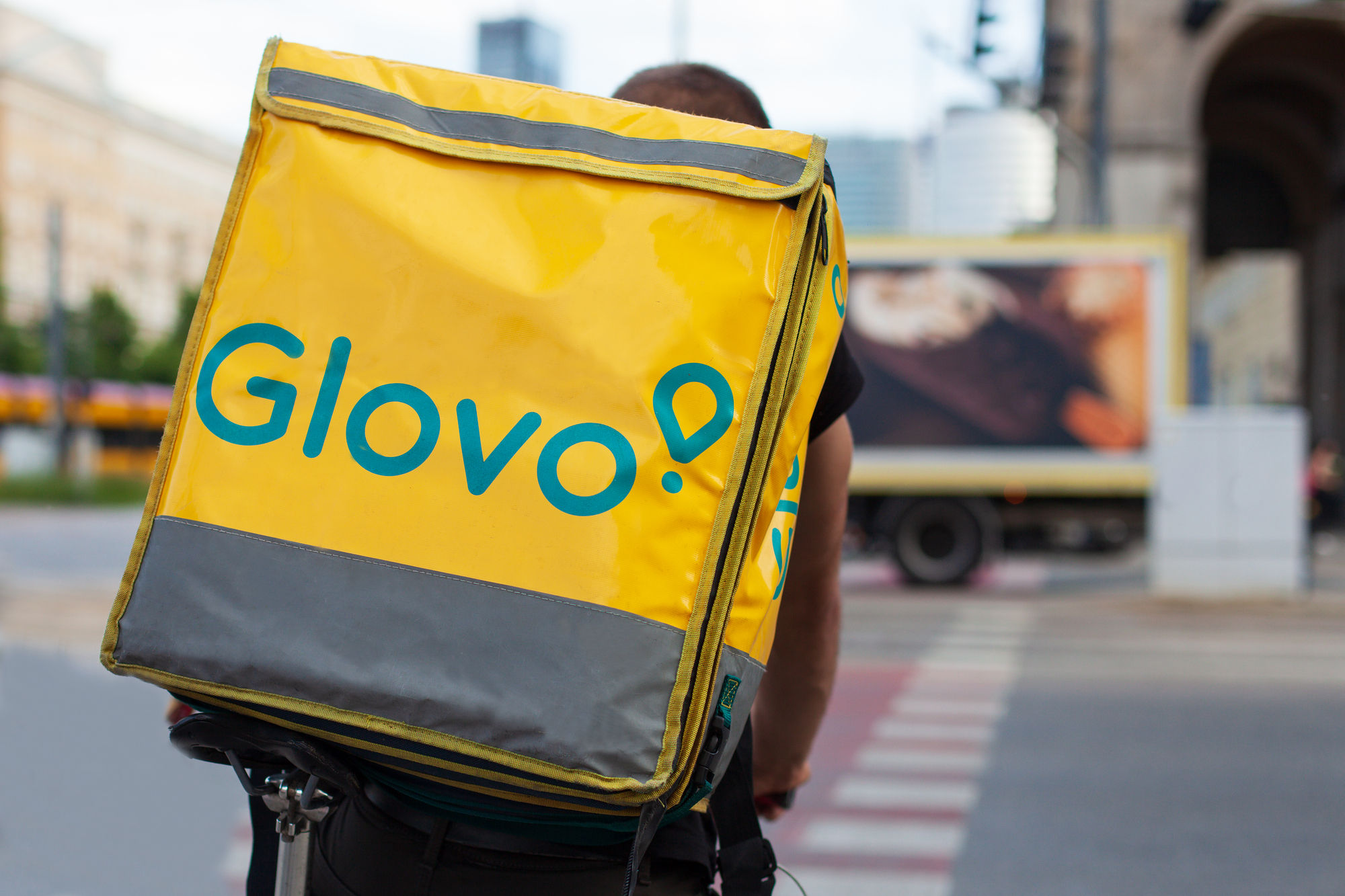Warsaw, Poznan - Jun 05, 2021: Glovo cyclist on the street in the city center. Food delivery. Close up of a bag.